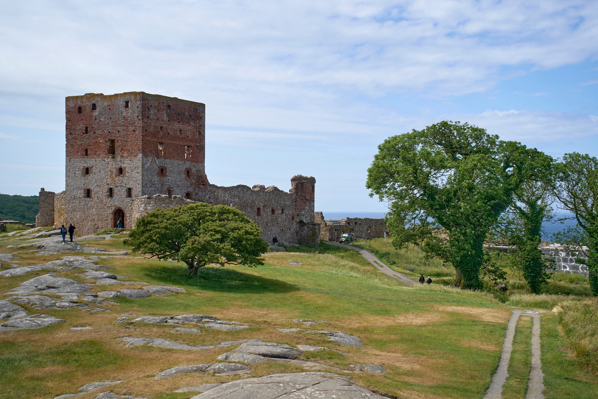 Die Ruine der Burg Hammershus mit dem Manteltaarn und Rundbastion hoch ueber der Kueste.